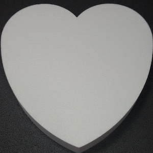 May include: White heart-shaped foam cake dummy. The dummy is smooth and has a slightly textured surface.