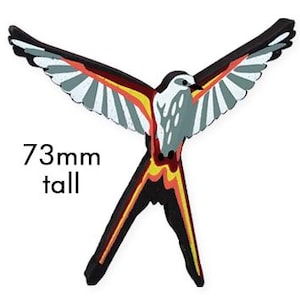 May include: A wooden bird figurine with red, orange, yellow, and black accents. The bird is in flight with its wings spread wide. It is 73 mm tall.