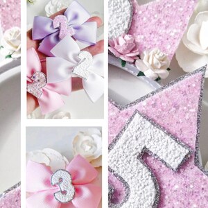 May include: A set of three pink, white and purple hair bows with silver glitter numbers two and three. The bows are displayed on a white background with pink glitter stars and a silver glitter crown.