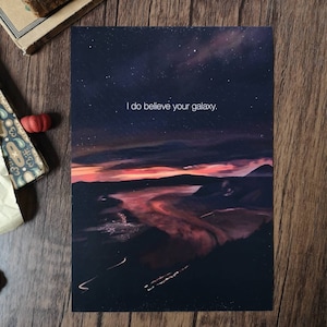 Pode incluir: Uma impress&atilde;o de gal&aacute;xia azul escuro e roxo com uma cita&ccedil;&atilde;o em texto branco que diz "Eu acredito na sua gal&aacute;xia."