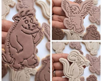 Op de afbeelding: Een set van bruine en beige koekjesvormen met personages uit het boek "Waar de Wilde Dingen Zijn". De vormen omvatten een bruin monster, een beige uil en een beige muis.