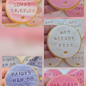 Puede incluir: Una colecci&oacute;n de galletas redondas con glaseado de fondant liso en patrones de m&aacute;rmol rosa, blanco y morado. Cada galleta presenta texto en relieve que incluye Bride Squad 08.08.26, Rebecca's Bridal Shower, Mrs. McCabe 2026, Paige's Hen Do y Pia Said Yes, acentuadas con un peque&ntilde;o coraz&oacute;n dorado.