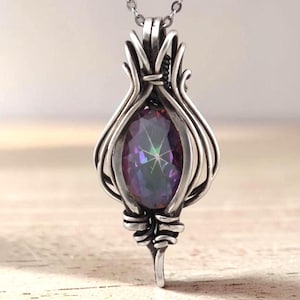 May include: A pendant necklace featuring an oval-shaped, iridescent, multi-colored gemstone encased in a complex, silver-toned wire-wrapped frame. The metal wire curves around the stone, creating a cage-like structure that hangs from a silver chain.