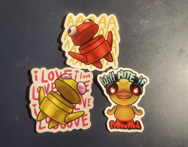 May include: Three cartoon stickers featuring stylized creatures. One is red with "AAAA" text, another is yellow with "I LOVE LOVE" text, and the last is yellow with "Will Bite if Provoked" text.