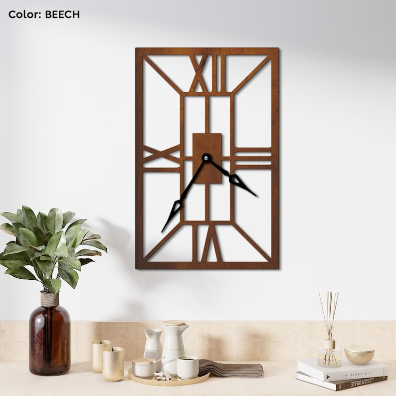 Rectangular wooden wall clock with an open-frame Roman numeral design in a beech color, featuring black clock hands, mounted on a white wall above a minimalist decor setup.