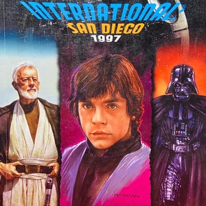 Può includere: Guida del programma della Comic-Con International di San Diego 1997 con illustrazioni di Obi-Wan Kenobi, Luke Skywalker e Darth Vader.