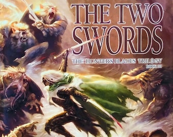 May include: A fantasy novel cover depicting a battle scene with several characters, including a warrior wielding two swords, a dark elf, and a group of orcs. The book title is "The Two Swords" by R.A. Salvatore. This book is part of the "Hunters Blades Trilogy" series.
