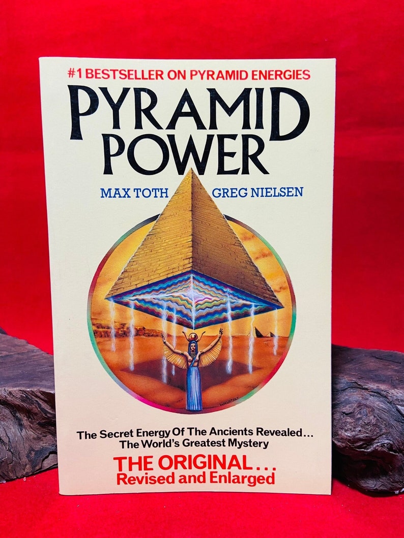 May include: A book cover with a yellow background and the title "Pyramid Power" in large, bold, black letters. The book cover features an illustration of a pyramid with a woman standing underneath it. The book cover also includes the text "#1 Bestseller on Pyramid Energies", "Max Toth", "Greg Nielsen", "The Secret Energy Of The Ancients Revealed...", "The World's Greatest Mystery", "THE ORIGINAL...", and "Revised and Enlarged".