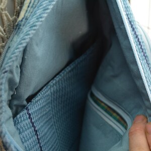 K&ouml;nnte beinhalten: Offene Ansicht einer hellblauen Jeans-Tasche, die das Innere zeigt. Die Tasche hat einen Rei&szlig;verschluss und ein hellblaues Futter. Es gibt eine Tasche aus strukturiertem Jeansstoff. Die Tasche ist offen und zeigt das Innere.