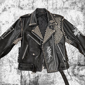 May include: Black leather motorcycle jacket with silver studs and a white graphic that says "Psychrock".