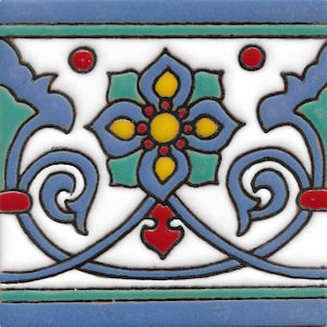 May include: A blue and white ceramic tile with a floral design. The tile features a central flower with yellow and red accents, surrounded by blue and green leaves.