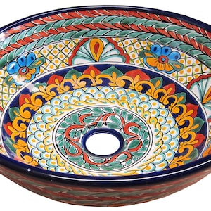 May include: A colourful ceramic sink with a blue, green, yellow, red and white floral pattern. The sink is round and has a drain hole in the centre.