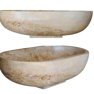 May include: A large, oval-shaped, freestanding bathtub made of natural stone. The bathtub has a light beige color with brown and gold streaks throughout. The bathtub is shown from two different angles.