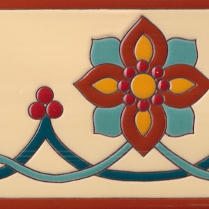 May include: A rectangular ceramic tile featuring a cream-colored background with a decorative border pattern. The design includes a central floral motif in red, yellow, and teal, connected by teal scrolling lines and accented with small red circles.