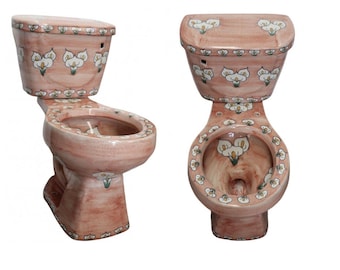 Op de afbeelding: Twee aanzichten van een keramisch toilet met een roze gemarmerde glazuurafwerking en een herhalend patroon van witte calla-leliebloemen met groene stelen. Het toilet bevat een bijpassende stortbak, pot en zitting.