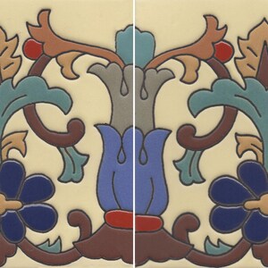 May include: A decorative ceramic tile featuring a repeating floral pattern on a cream background. The design includes stylized blue flowers, teal leaves, brown scrolls, and small red accents, creating a symmetrical and colorful botanical motif.