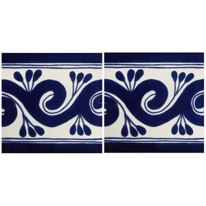 May include: Two square tiles with a repeating blue and white decorative pattern. The design features a stylized wave with floral elements. The border is a solid blue line. The background is white.