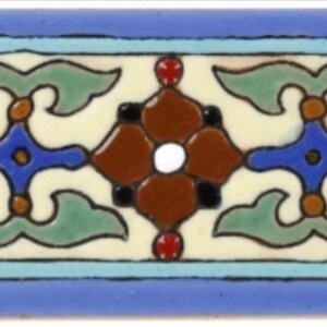 May include: A decorative tile border with a repeating pattern of brown, blue, green, and white floral motifs on a cream background. The border is framed by a light blue band.
