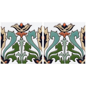 May include: Two ceramic tiles with a white background and a repeating pattern of stylized green, blue, orange, and black floral designs.