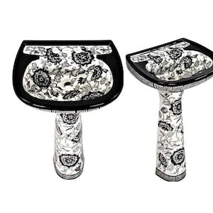 May include: A black and white pedestal sink with a floral design. The sink is made of ceramic and has a rounded shape. The pedestal is also decorated with a floral design.