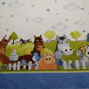 May include: A white fabric with a blue border and a green and white farm scene. The scene includes a donkey, a horse, a pig, a cow, a chicken, and a rooster. There are also clouds and stars in the background.