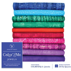 May include: A stack of 10 fat quarter fabric bundles in various shades of blue, green, red, pink, and purple. The fabric has a subtle shimmer and a speckled pattern. The fabric bundle is labeled "Color Me Jewels" and "COLMFATQ-3 - Jewels".