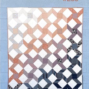 May include: A patchwork quilt with a geometric design in shades of white, orange, purple, and navy blue. The quilt features a repeating pattern of intersecting squares and rectangles. The text "Liverpool Lane #259" and "Cotton Street Commons" are visible.