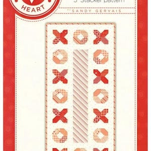 May include: A fabric pattern featuring the text "XOX" in a repeating design of red and peach-colored Xs and Os. The pattern is on a white background with a red border. The text "Pieces From My Heart" is in a red circle.