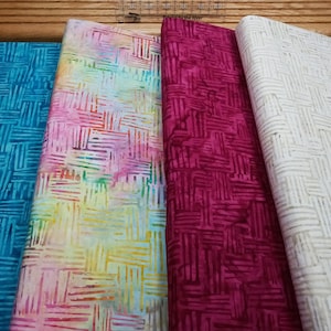 May include: Four fabric swatches with a geometric pattern. The swatches are in shades of teal, pink, yellow, red, and white.