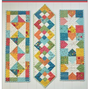 May include: A colorful quilt pattern book titled "Little Charmers 2" featuring three quilt designs. The designs include geometric patterns with squares and diamonds in various colors like blue, yellow, and pink. The book is "5" Square Friendly".