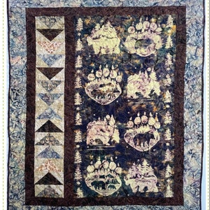 May include: A pieced panel quilt with a dark blue background featuring bear paw prints and forest scenes. The quilt has a brown border and a patterned border. The text "Sidewalk" and "Quilting Renditions" are visible.