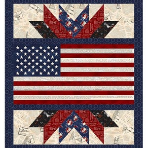 May include: A patriotic quilt featuring the American flag with red and white stripes and a field of white stars on a blue background. The quilt has a blue border with white dots and star-shaped patterns.