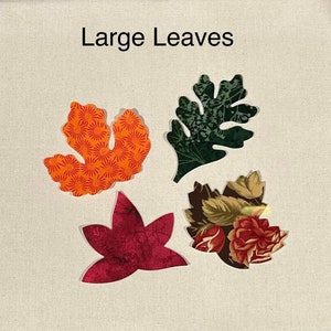 May include: Four fabric leaves in different colors and patterns. The leaves are cut out and placed on a beige fabric background. The text "Large Leaves" is printed above the leaves.