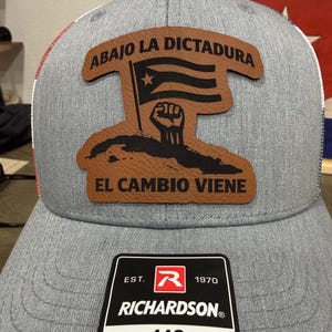 May include: A white ceramic mug with a black handle and the text "But First, Coffee" in a handwritten style. The mug is on a white surface. The mug is approximately 4 inches tall.