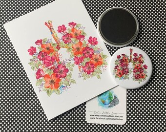 May include: A white card, a magnet, and a button featuring a watercolor illustration of lungs adorned with red and orange flowers. The card and button have the same design. A small business card is also present.