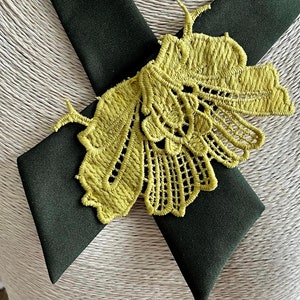 Könnte beinhalten: Eine dunkelgrüne Fliege mit einem gelben Spitzen-Schmetterlingsdesign.