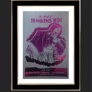 K&ouml;nnte beinhalten: Ein Vintage-Filmplakat f&uuml;r den Film "Die Braut des Frankenstein" mit einer Schwarzwei&szlig;illustration von Boris Karloff als Frankensteins Monster und Elsa Lanchester als Braut von Frankenstein. Das Plakat ist auf silbernem Hintergrund mit rosa und violetten Akzenten gedruckt.