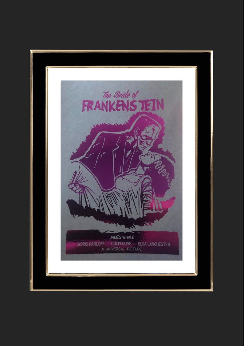K&ouml;nnte beinhalten: Ein Vintage-Filmplakat f&uuml;r den Film "Die Braut des Frankenstein" mit einer Schwarzwei&szlig;illustration von Boris Karloff als Frankensteins Monster und Elsa Lanchester als Braut von Frankenstein. Das Plakat ist auf silbernem Hintergrund mit rosa und violetten Akzenten gedruckt.