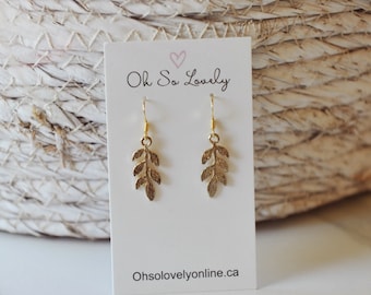 May include: Gold leaf dangle earrings on a white card with the text "Oh So Lovely" and "Ohsolovelyonline.ca".