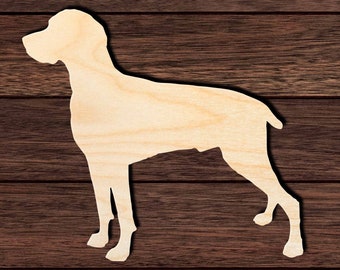 Op de afbeelding: Een houten uitsnijding van een hond in staande positie. De uitsnijding is gemaakt van onbehandeld hout en is klaar om te worden geschilderd of beitsen.
