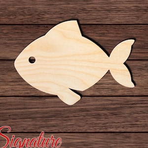 May include: A wooden cutout of a fish shape. The fish is light brown and has a simple design. The cutout is on a brown wooden background.