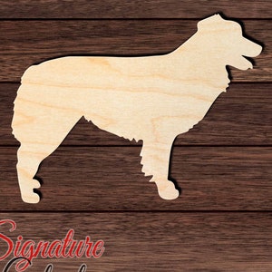 May include: A wooden cutout of an Australian Shepherd dog in profile, standing on a brown wood background. The cutout is unpainted and has a natural wood finish.