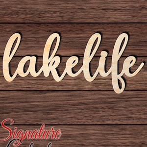 May include: Wooden cutout of the word "lakelife" in a cursive font. The cutout is on a brown wood background.