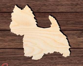 Op de afbeelding: Een houten uitsnijding in de vorm van een West Highland White Terrier hond. De uitsnijding is ongeverfd en heeft een natuurlijke houtkleur. De uitsnijding bevindt zich op een bruine houten achtergrond.