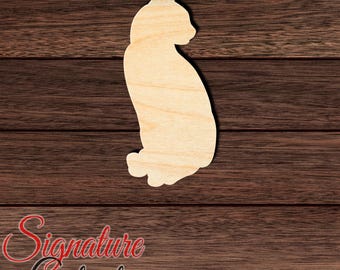 May include: A light-colored wooden cutout in the shape of a sitting cat, featuring a smooth surface with visible natural wood grain patterns. The silhouette shows the cat in profile, facing right, with pointed ears and a rounded back and tail.
