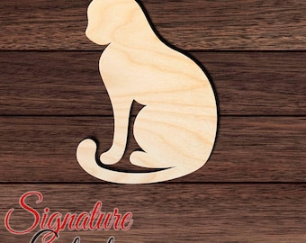 May include: A light-colored wooden cutout in the shape of a sitting cat with a smooth surface and visible wood grain. The silhouette features a pointed ear, a curved back, and a tail that wraps around the base of the feline figure.