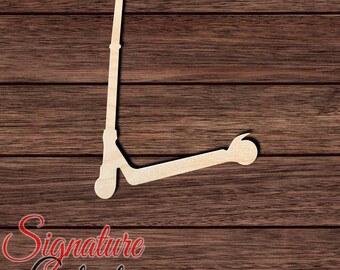 May include: A light-colored wooden cutout in the shape of a kick scooter. The silhouette features a vertical handlebar stem with a horizontal grip at the top, a long narrow deck, and a small circular wheel at the rear. The surface is smooth and flat.