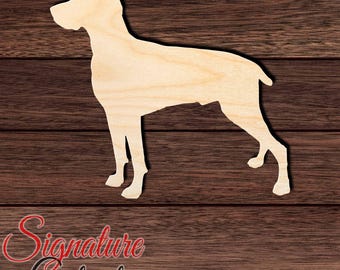Könnte beinhalten: Ein hellfarbener Holzausschnitt in Form eines stehenden Hundes, von der Seite betrachtet. Die Silhouette zeigt eine spitze Schnauze, aufrechte Ohren und einen schlanken Körper mit vier sichtbaren Beinen. Die Oberfläche weist eine natürliche Holzmaserung auf.