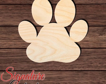 May include: A light-colored wooden cutout in the shape of an animal paw print, featuring a large central pad and four smaller rounded toe pads. The surface displays a natural wood grain pattern with a smooth, flat finish and clean edges.