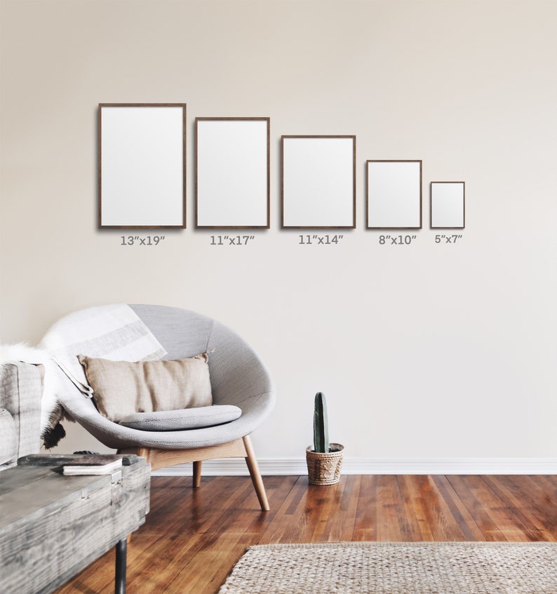 May include: Five framed pictures of different sizes hanging on a beige wall. The frames are brown wood and the pictures are blank. The frames are 13 inches by 19 inches, 11 inches by 17 inches, 11 inches by 14 inches, 8 inches by 10 inches, and 5 inches by 7 inches.